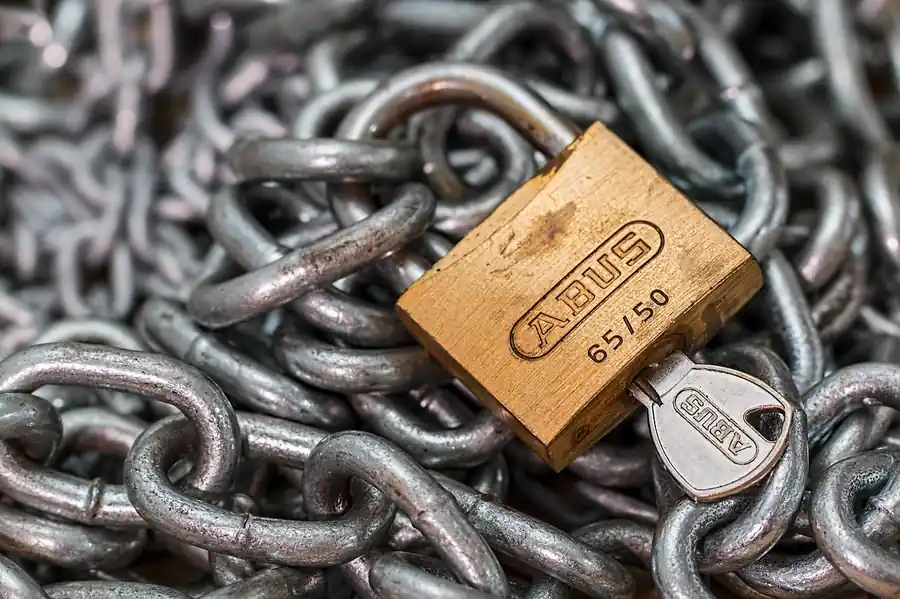 Vorhaengeschloss mit Schluessel und Kette als Symbol fuer Zugriffskontrolle und File-Server-Berechtigungen