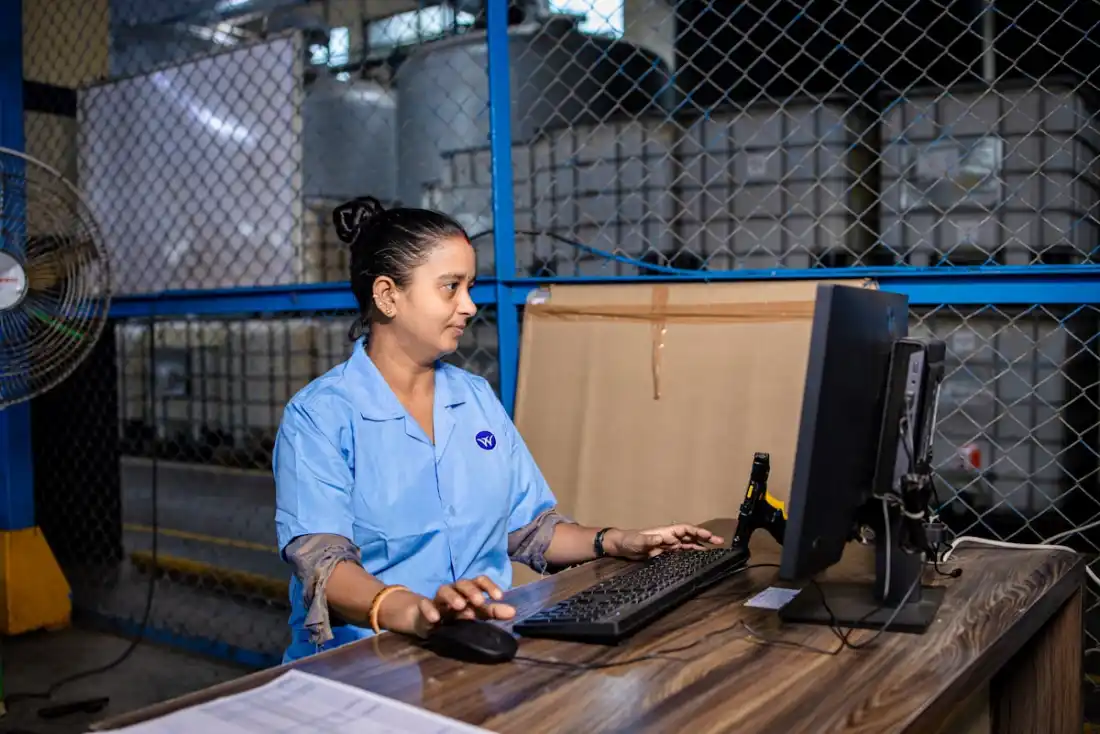 Lagerarbeiterin steuert IoT-basiertes Asset-Tracking-System am Computer