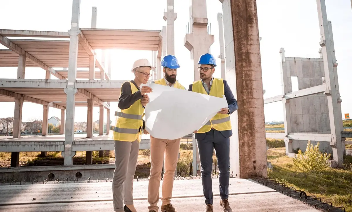 Serverraum Projektplan — Ingenieur-Team mit Helm prüft Baupläne in der Umsetzungsphase